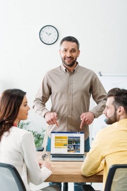 erkek ve kadın ofiste laptop ekranında rezervasyon Web sitesi ile parmaklarıyla işaret Danışmanı