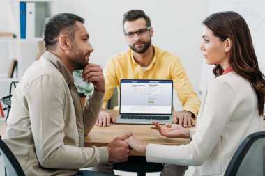 erkek ve kadın adlı tablo wile Danışmanı Office Web sitesi facebook ile dizüstü bilgisayar ile oturup el ele tutuşarak seçici odak
