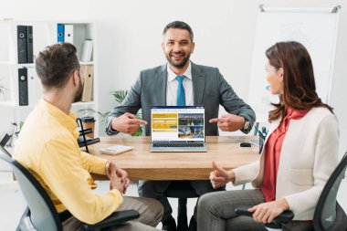 laptop ekranında yatırımcılar Office yakınındaki rezervasyon Web sitesi ile parmaklarıyla işaret Danışmanı