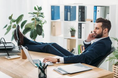 mavi elbiseli masa bacaklarına ve Office smartphone cep telefonu ile konuşurken oturan işadamı