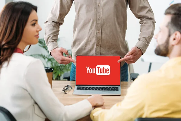 オフィスでカップルに Youtube のウェブサイト上のラップトップで指で指しているアドバイザーの選択と集中 — ストック写真