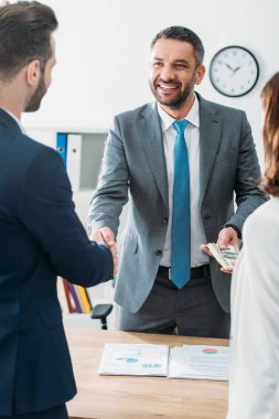 seçici odak yatırımcılar ile el sıkışan ve Doları banknot göreve Danışmanı 