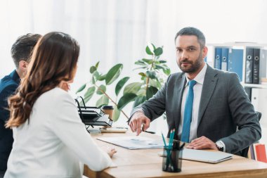 yakışıklı danışmanı ve yatırımcılara office belgesindeki tartışırken takım elbiseli seçici odak 