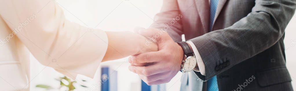 cropped view of man and woman shaking hands at office 