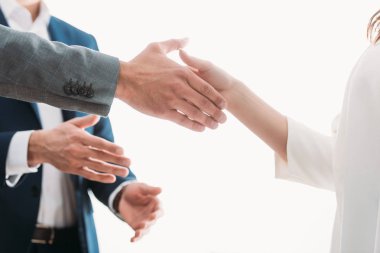 selective focus of men and woman shaking hands at office  clipart