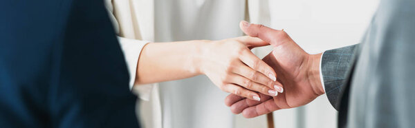 selective focus of man and woman shaking hands at office 