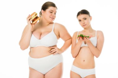 kilolu mutlu kadın üzerinde beyaz izole burger yemek sırasında ince kadın iç çamaşırı yeşil ıspanak tutan yaprakları