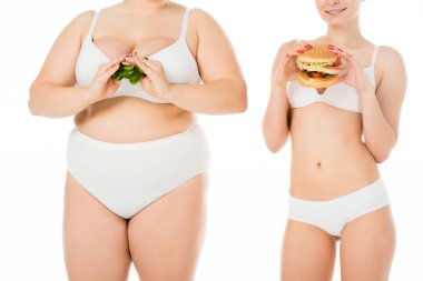 ince gülümseyen kadın iç çamaşırı burger yeşil ıspanak yaprakları üzerinde beyaz izole tutan kilolu kadın süre tutan
