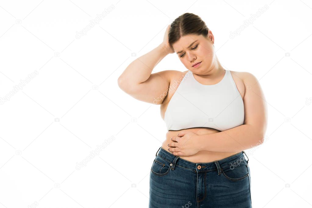 sad overweight woman in denim touching belly isolated on white