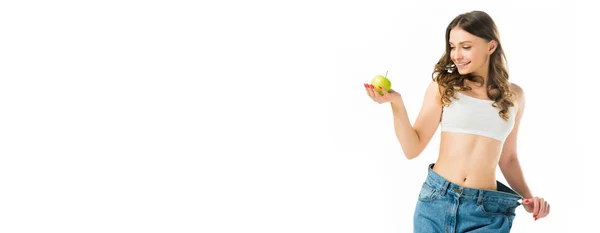 Улыбающаяся Стройная Молодая Женщина Больших Джинсах Держит Спелое Зеленое Яблоко — стоковое фото