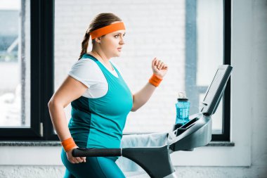 spor salonunda treadmill çekici kilolu kız workouting