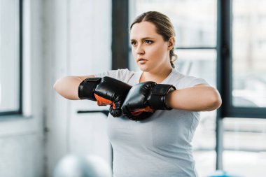 Kendine güvenen kilolu kız boks eldivenleri ayakta