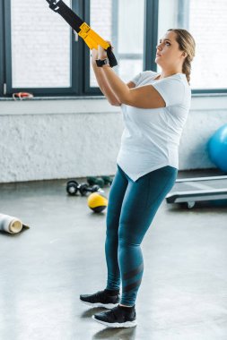 kilolu kadın eğitim silah spor salonunda askı kayışları ile