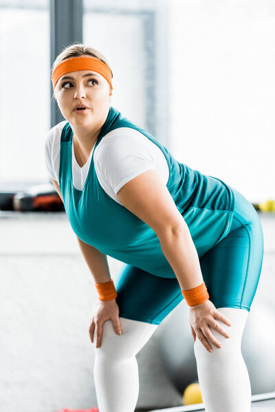 attractive overweight girl in sportswear workouting in gym 