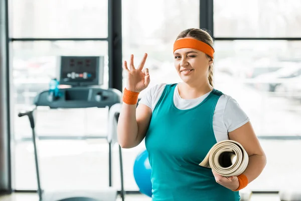 Fröhliche Übergewichtige Frau Zeigt Zeichen Während Sie Fitnessmatte Fitnessstudio Hält — Stockfoto