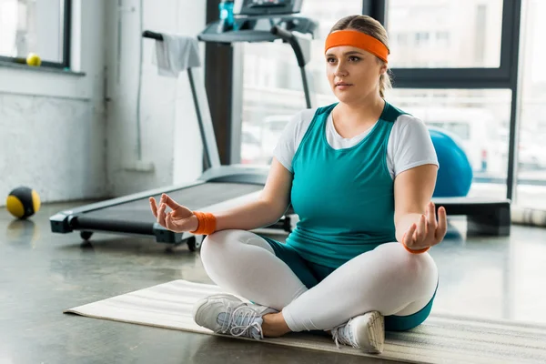 Focused Size Woman Sitting Fitness Mat Sport Equipment Crossed Legs — Stock Photo, Image