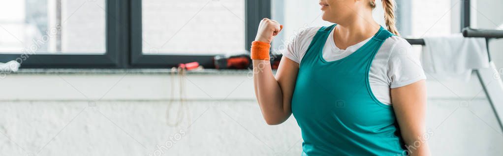 cropped view of plus size girl in sportswear exercising in gym