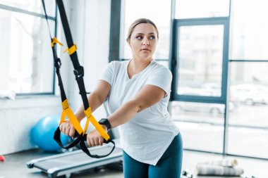 güzel kilolu kadın eğitim silah spor salonunda askı kayışları ile