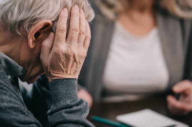 selective focus of senior man with hand on head having headache  clipart