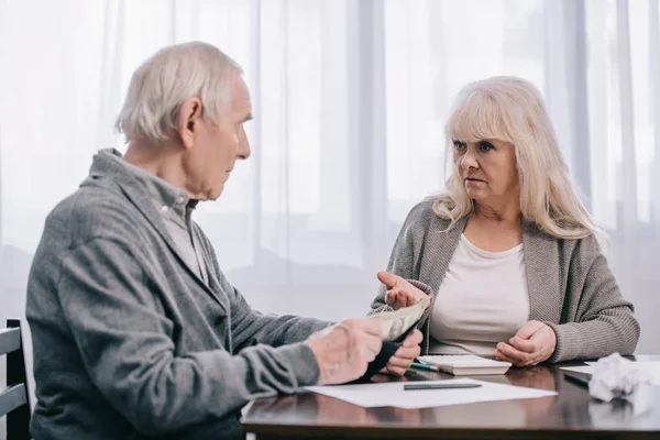 senior couple having discussion while sitting at table with paperwork