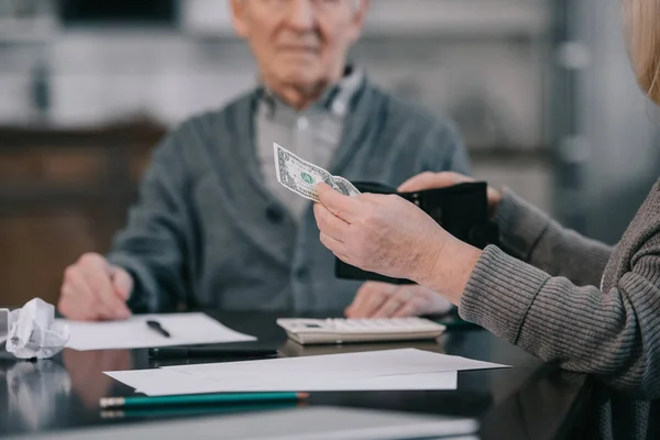 Oříznutý Pohled Starší Ženy Držící Peněženku Peníze Zatímco Sedí Stolu — Stock fotografie