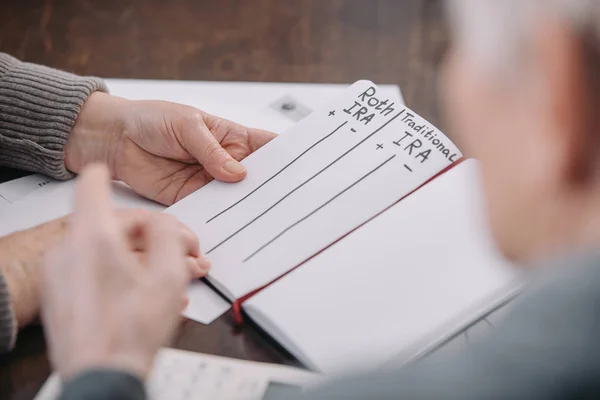 Seniorenpaar Hält Notizbuch Mit Roth Ira Und Traditionellen Ira Worten — Stockfoto