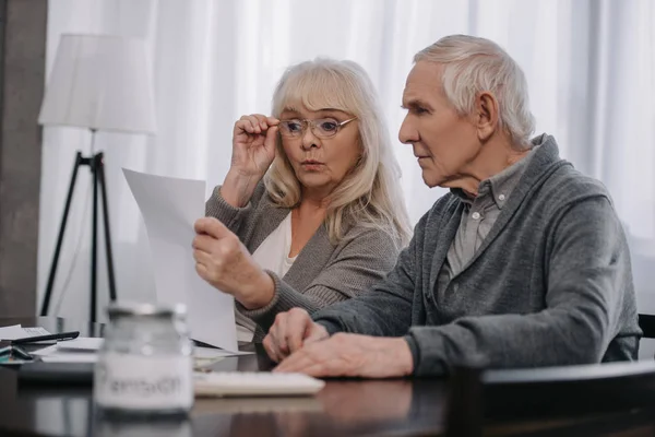 Sorprendido Pareja Ancianos Sentado Mesa Mirando Las Facturas — Foto de Stock