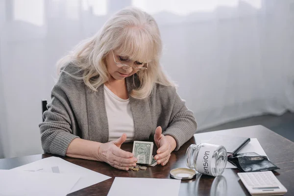 Старшая Женщина Сидит Столом Деньгами Бумажной Работой Пустой Стеклянной Банкой — стоковое фото