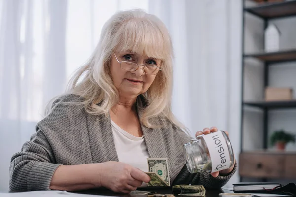 Senior Kvinna Tittar Kameran Hålla Glasburk Med Pension Word Och — Stockfoto