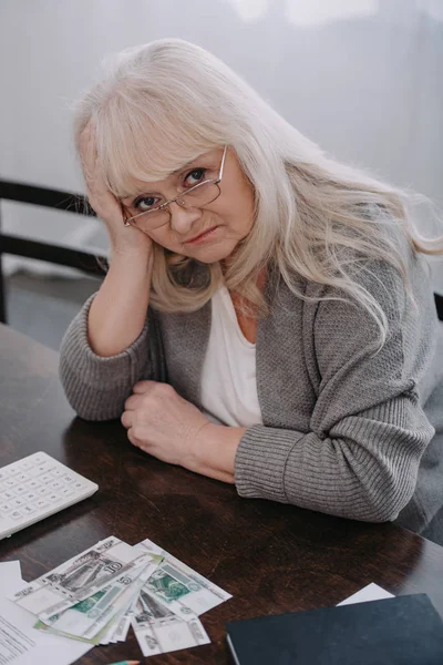 Mulher Sênior Sentada Mesa Com Dinheiro Olhando Para Câmera Tendo — Fotografia de Stock