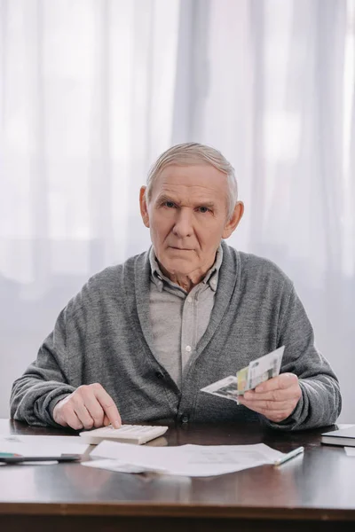 Senior Man Sitting Table Paperwork Looking Camera Using Calculator While — Stock Photo, Image
