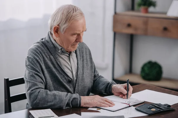 Senior Man Sitting Table Paperwork Writing Notebook — Stock Photo, Image
