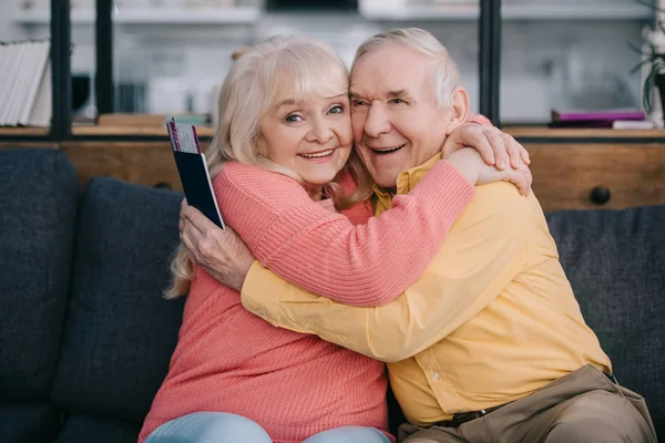 Happy Senior Couple Hugging Holding Air Tickets Passports Home — Stock Photo, Image