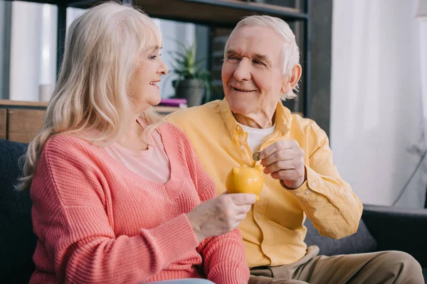 Happy Senior Couple Putting Coin Yellow Piggy Bank — Stock Photo, Image