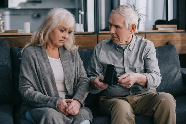 Sad Senior Couple Sitting Couch Holding Wallets Home — Stock Photo, Image