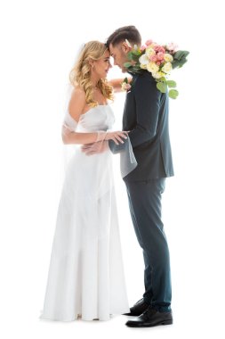 beautiful bride in white wedding dress, and groom in elegant black suit standing face to face isolated on white clipart