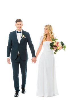 Beyaz gelinlikle elele yakışıklı damat ile üzerine beyaz izole şık elbiseli çekici gelin