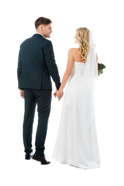 back view of bride in white wedding dress and groom in black suit isolated on white