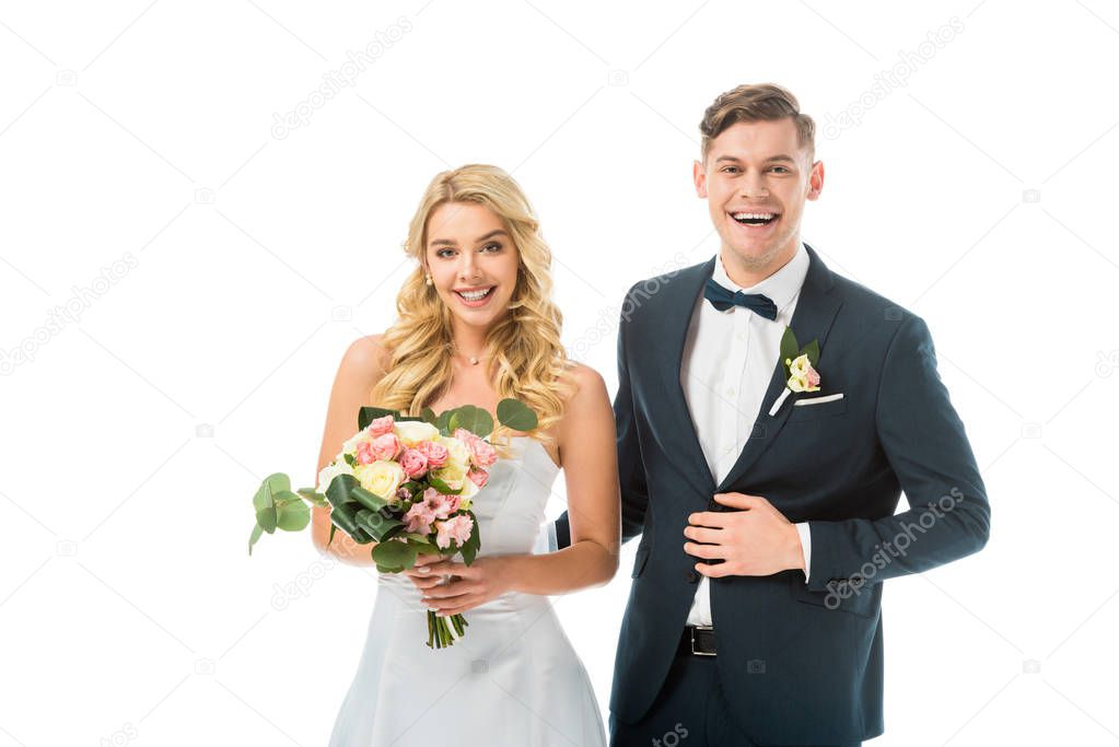 smiling bride with beautiful wedding bouquet, and groom in elegant black suit isolated on white