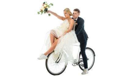 güzel gelin düğün buket bisiklet üzerinde beyaz izole damat birlikte otururken yükseltilmiş elinde tutan