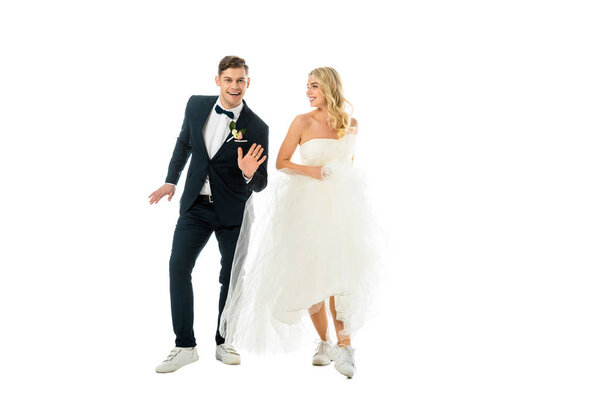 счастливая пара танцует в элегантной одежде и кроссовки изолированы на белом
