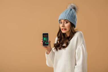Üzerinde bej kazaklı smartphone ile pazarlama analiz app ekranda tutan çok karışık kız izole