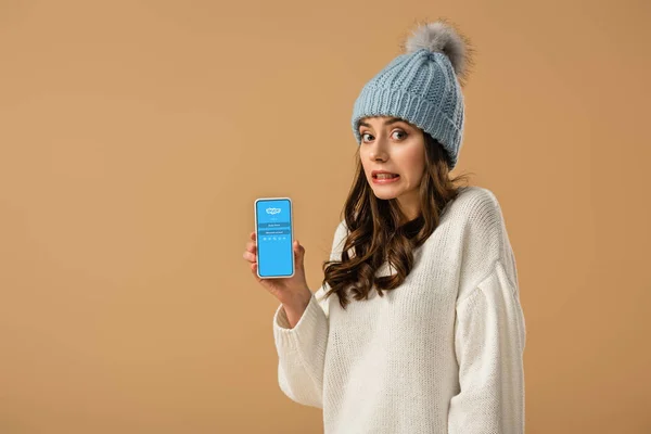 Confused Young Woman Knitted Hat Holding Smartphone Skype App Screen — Stock Photo, Image