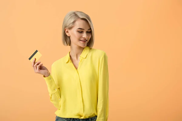 Uroczy Kobieta Blonde Żółta Koszulka Posiadania Karty Kredytowej Pomarańczowym Tle — Zdjęcie stockowe