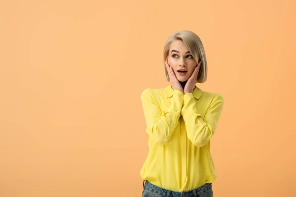 Mujer Rubia Conmocionada Camisa Amarilla Tocando Cara Mirando Hacia Arriba — Foto de Stock