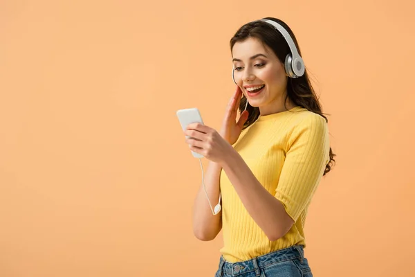 Joyful Brunette Girl Headphones Using Smartphone Smile Isolated Orange — Stock Photo, Image