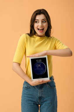 Turuncu üzerinde izole kilit ekranı ile dijital tablet holding neşeli esmer kız