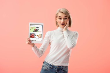 pink izole ekranda dijital tablet ebay app ile tutan sürpriz sarışın kadın 