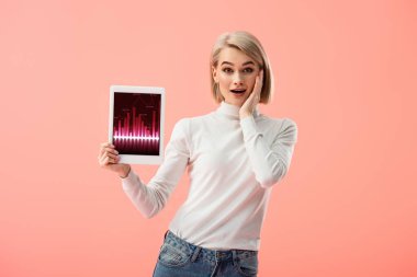 pink izole ekranda grafikler ile dijital tablet tutan sürpriz sarışın kadın 