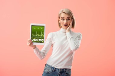 pink izole ekranda dijital tablet sağlık app ile tutan sürpriz sarışın kadın 